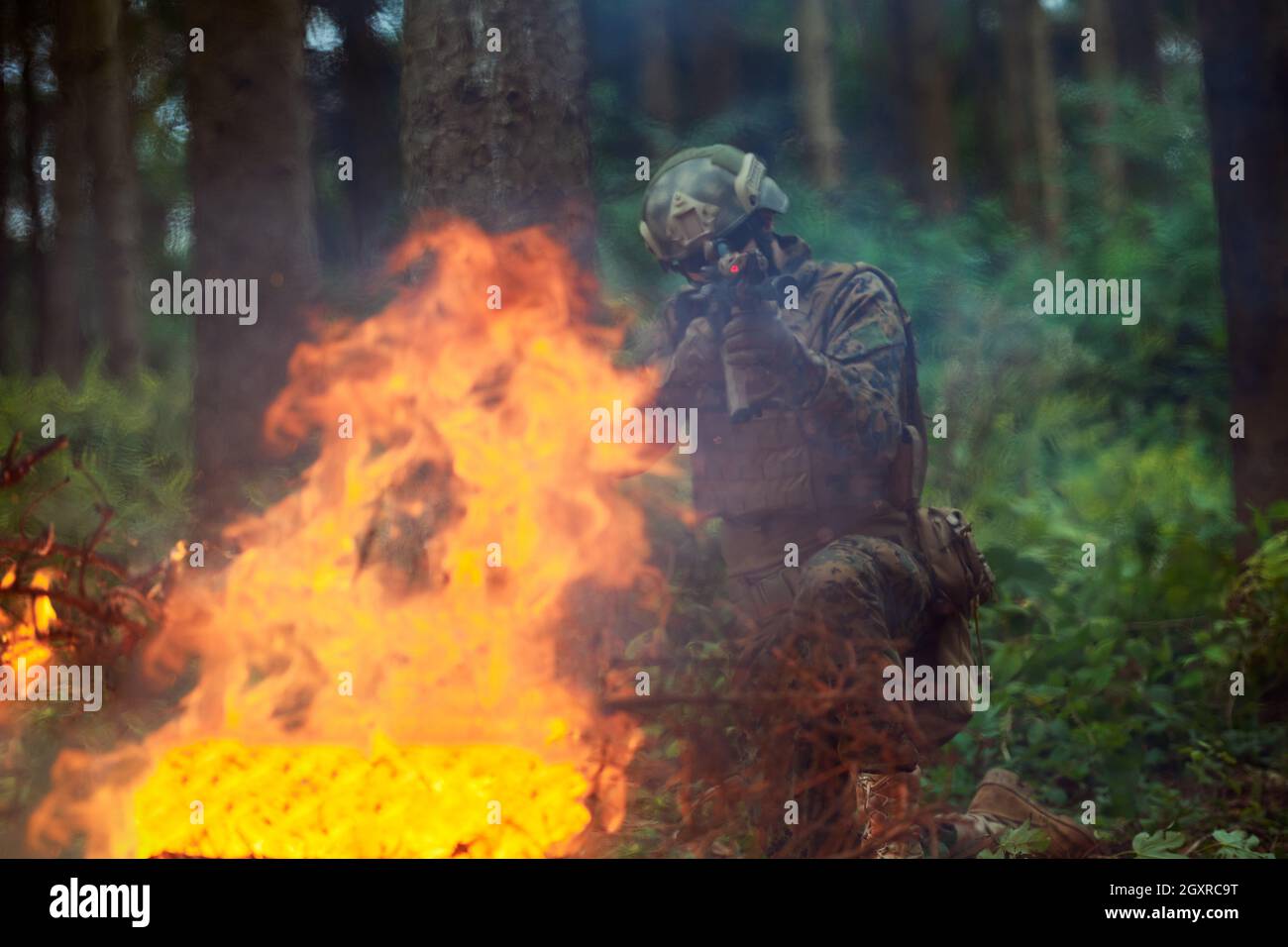 un moderno soldato di guerra in azione che punta all'arma ottica a vista laser in posizione di combattimento mentre cerca un bersaglio in battaglia Foto Stock