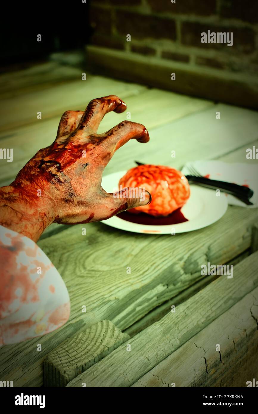 Sanguinoso zombie mano che raggiunge per fresco cervelli a mangiare per la cena Foto Stock