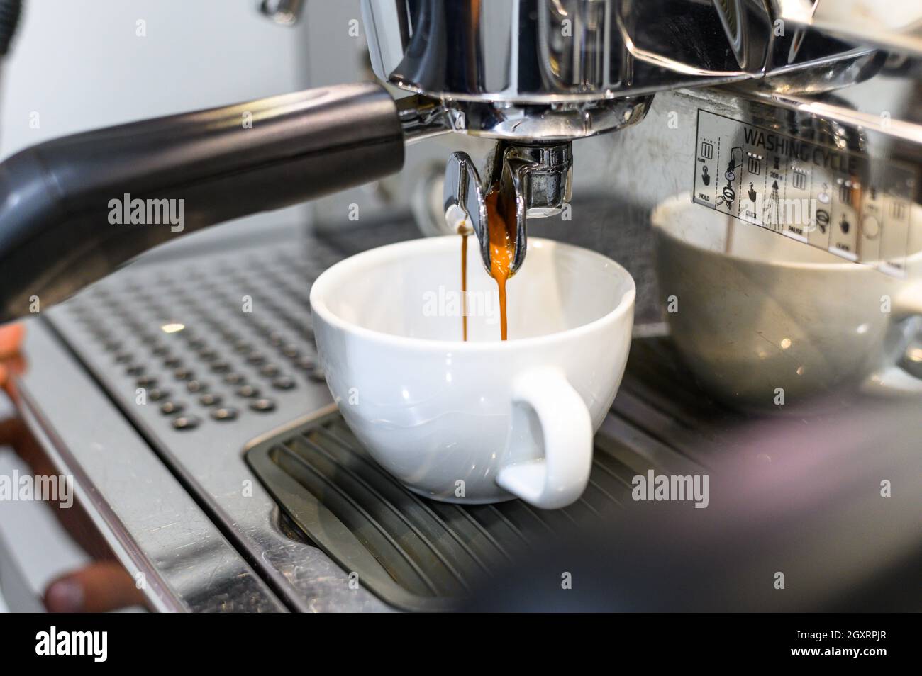 prepara l'espresso nella sua caffetteria; primo piano Foto Stock