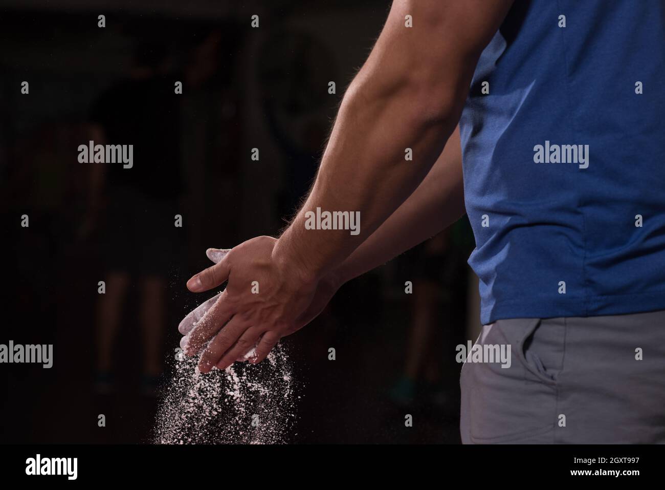 Palestra Chalk carbonato di magnesio battendo le mani uomo per allenamento di arrampicata Foto Stock