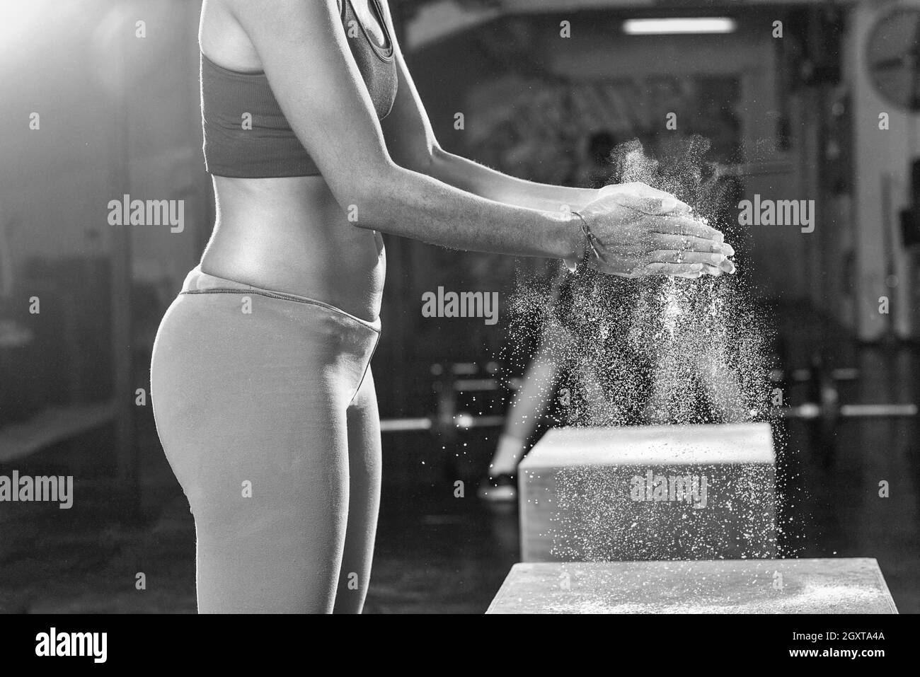 Palestra Chalk carbonato di magnesio battendo le mani giovane africano donna americana per allenamento di arrampicata Foto Stock