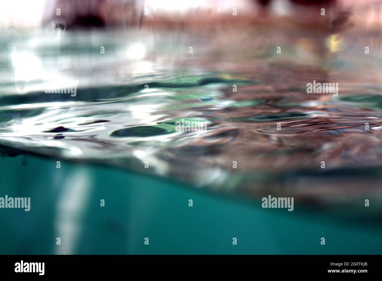 Acqua i modelli di superficie contro una superficie di vetro in un acquario Foto Stock