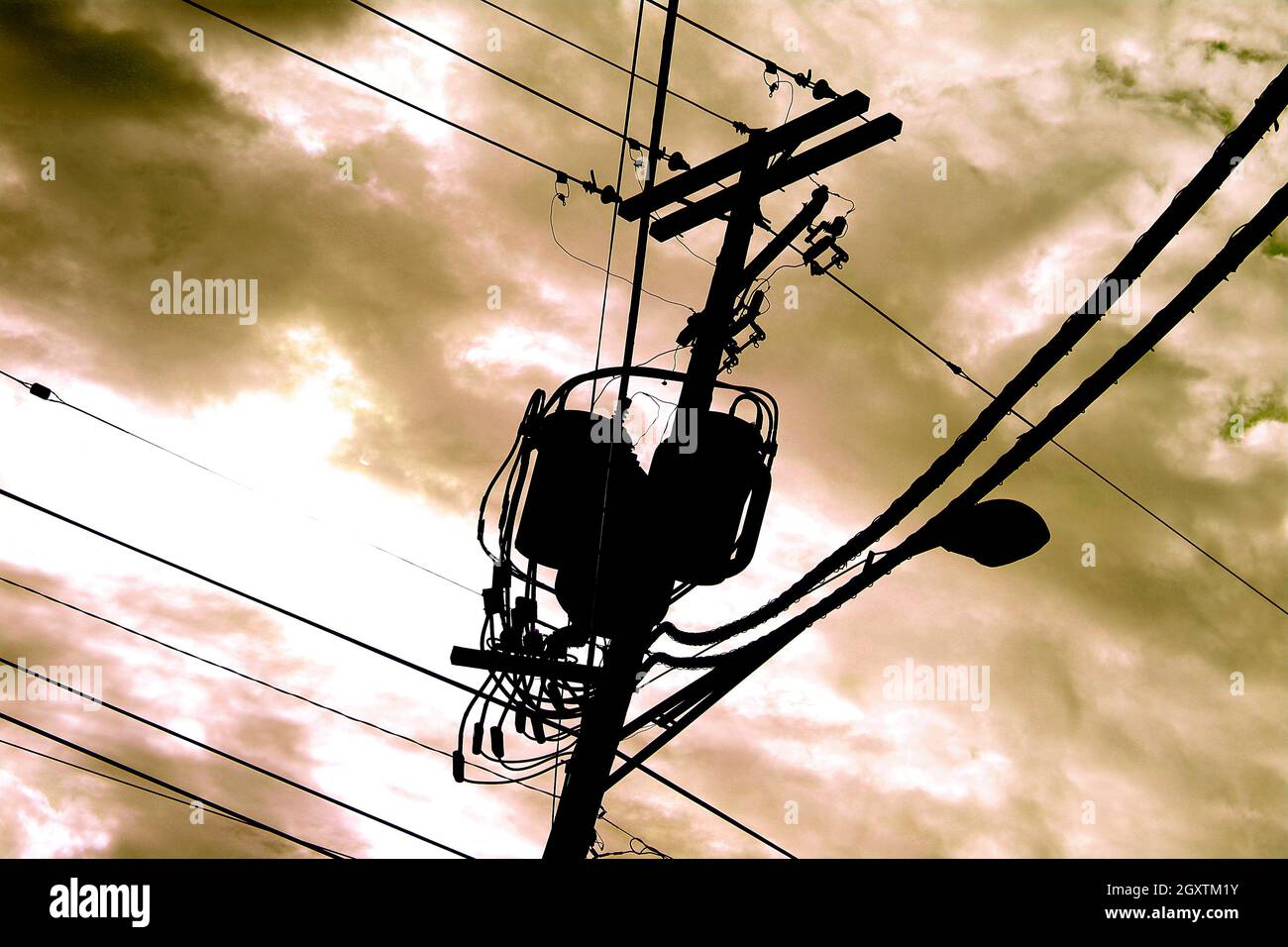 Telefono polo macchinari contro un giallo arancione cielo nuvoloso Foto Stock