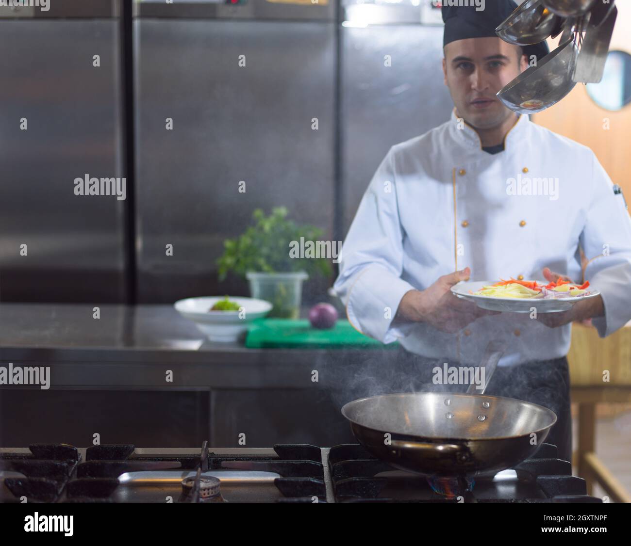 Lo chef prepara cibi, frittura in padella wok. La vendita e il concetto di cibo Foto Stock