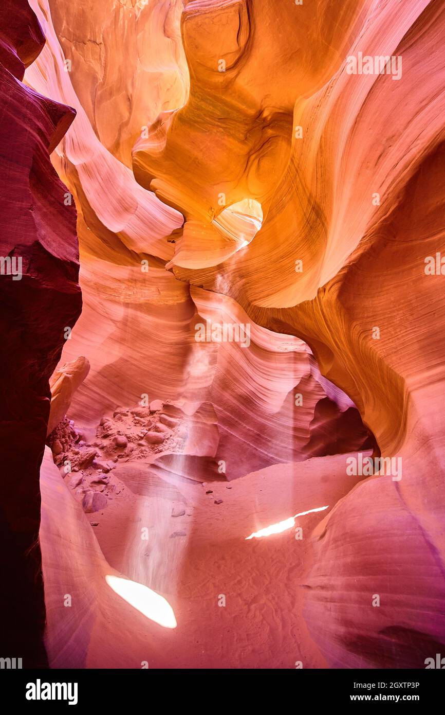 La luce attraversa la roccia di un canyon arancione Foto Stock