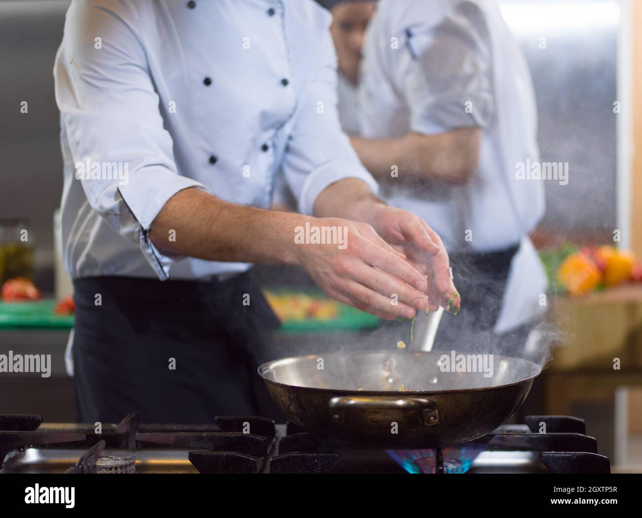 Lo chef prepara cibi, frittura in padella wok. La vendita e il concetto di cibo Foto Stock