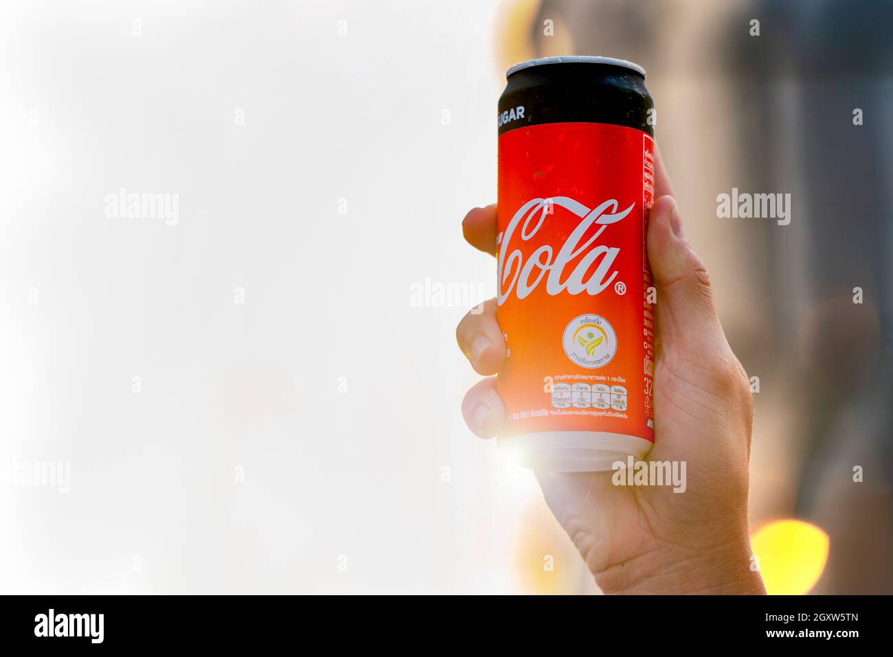 Coca Cola drink in mano. Ragazzo che sale può alla luce del sole. L'uomo che tiene e beve Coca Coca Cola con faccia felice al tramonto. BANGKOK,THAILANDIA - 2 FEBBRAIO 2020. Foto Stock