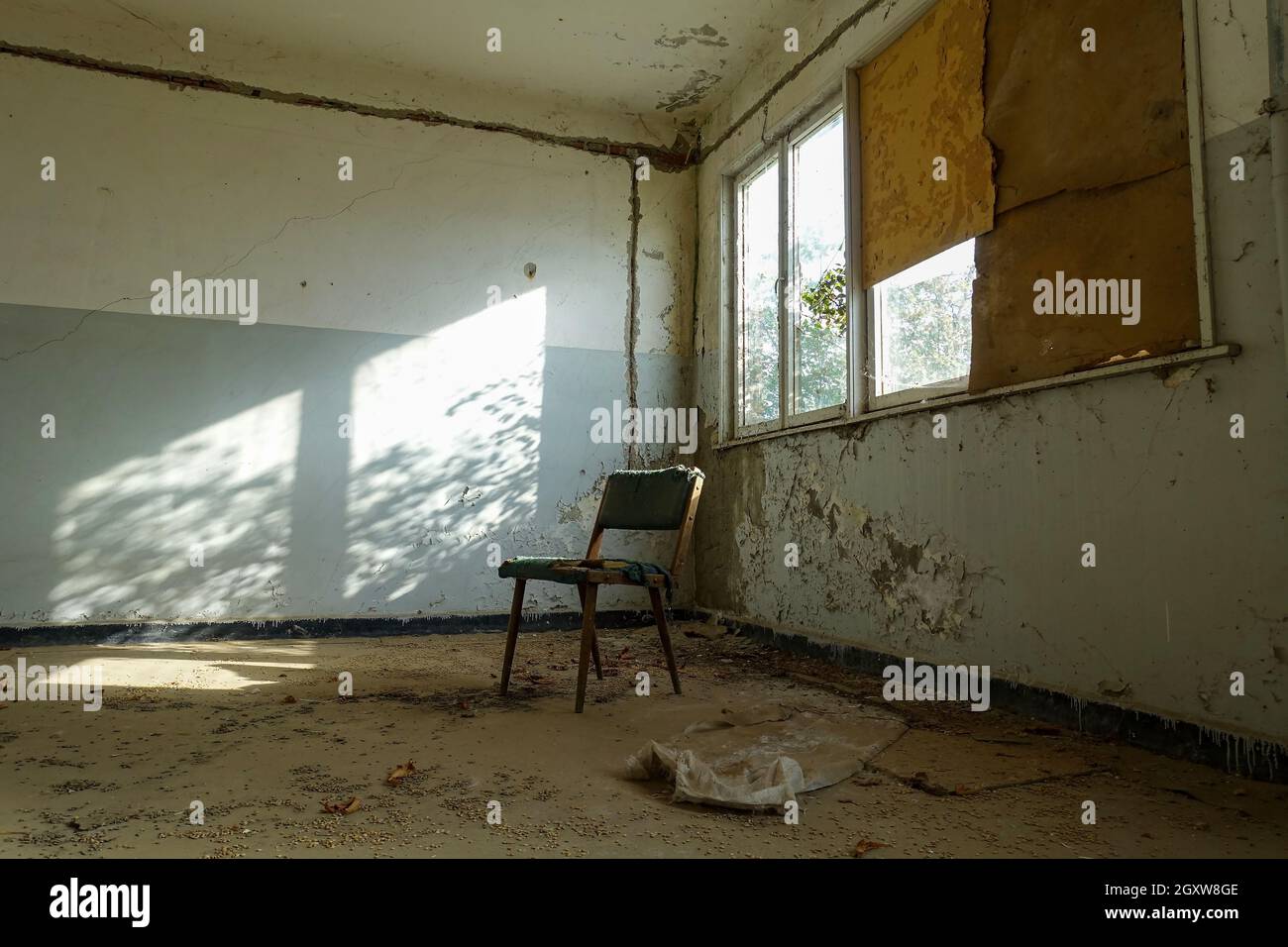 vecchia sedia nell'angolo di una camera sporca Foto Stock
