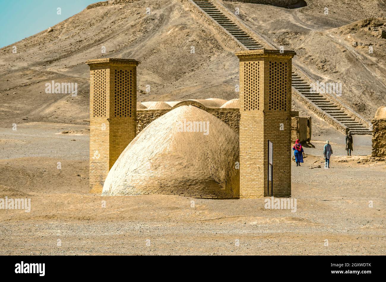 Yazd, Iran, 21 marzo 2021:cupola in adobe per il trattamento delle acque reflue con due torri di ventilazione sullo sfondo di scale di pietra che conducono ad un rimorchiamento di sepoltura Foto Stock