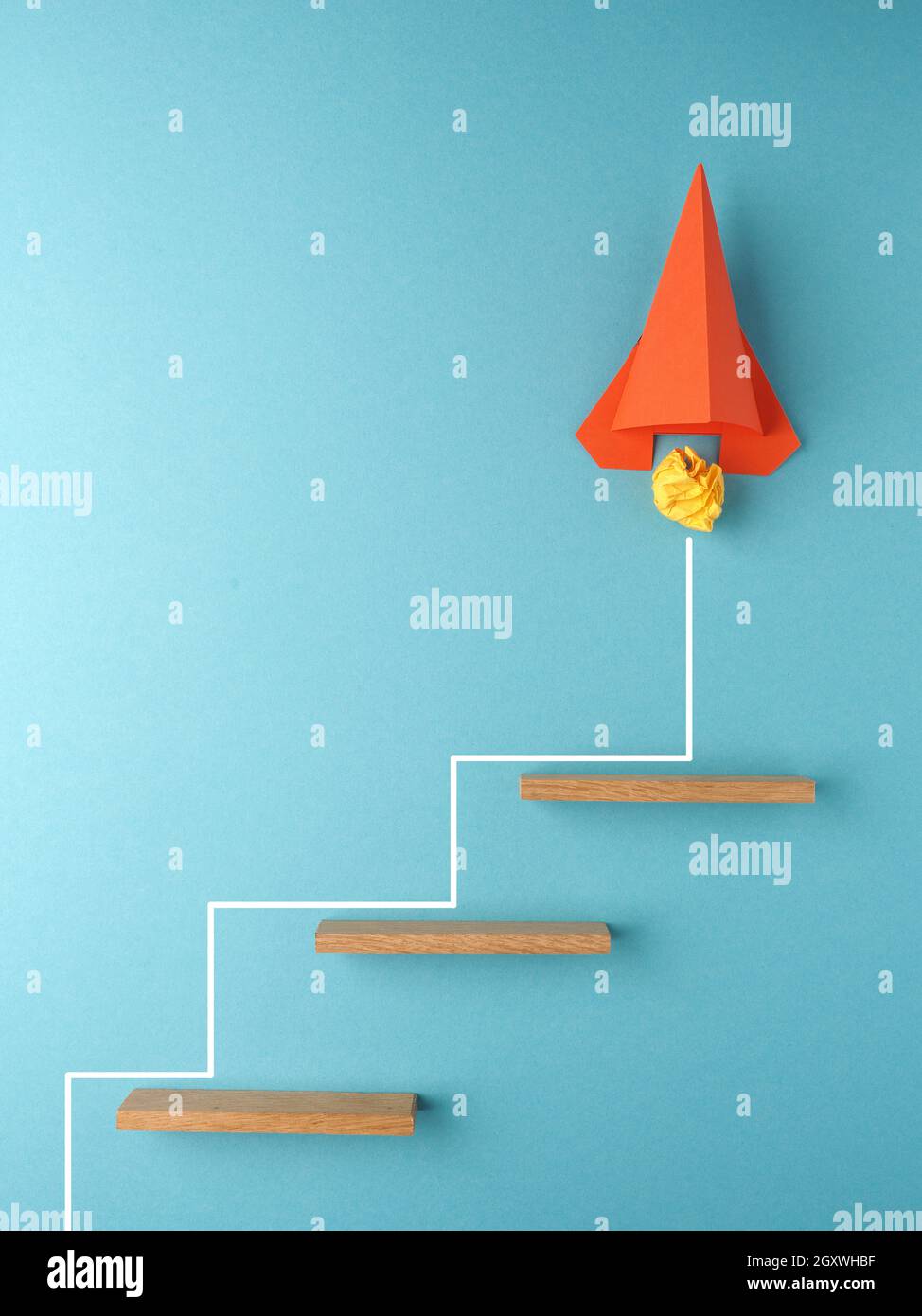 Razzo arancione o stella che sale le scale su sfondo blu, concetto di successo o creatività, startup, innovazione Foto Stock