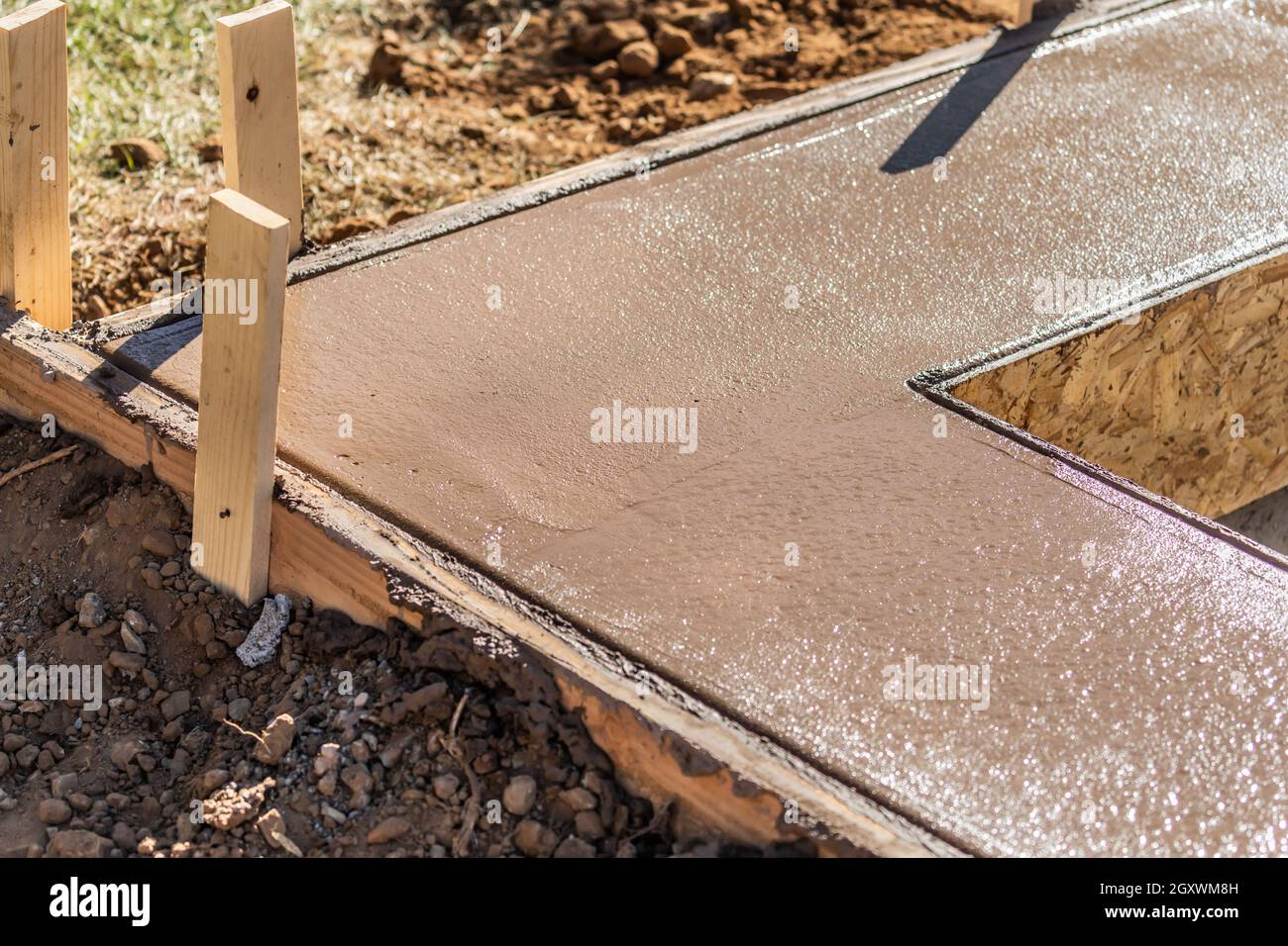 Piscina fresca di coping di essiccazione del cemento all'interno di incorniciatura di legno. Foto Stock