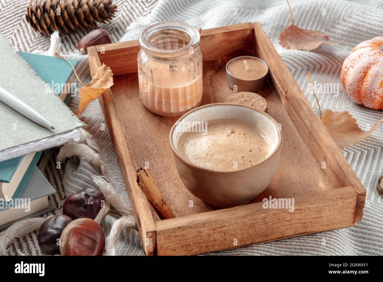 Hygge ancora vita con una tazza di caffè e candele profumate su una coperta calda, confortevole scena interna Foto Stock