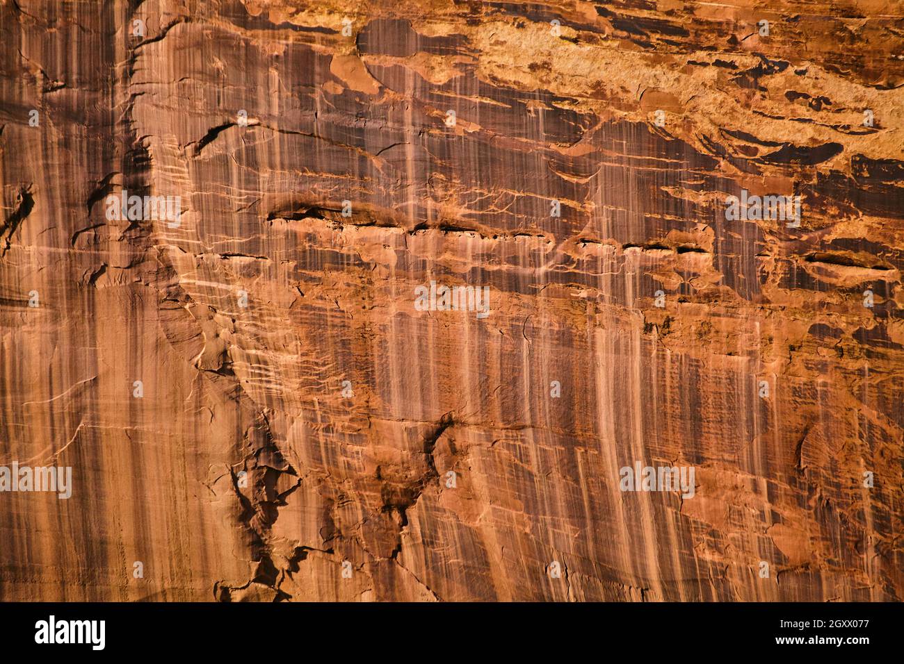 Segni verticali su grandi pareti in pietra rossa e arancione Foto Stock