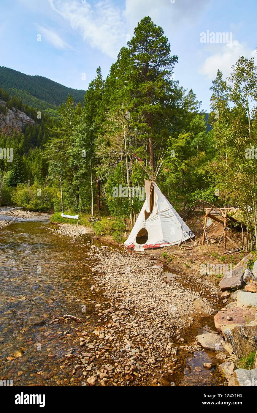 Vecchia tenda indiana vicino al fiume in montagna Foto Stock