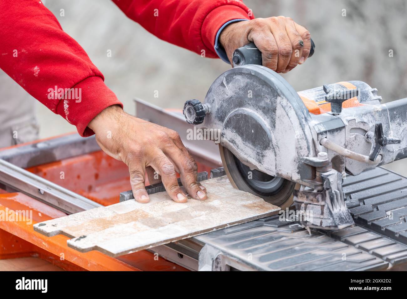 Lavoratore usando piastrelle umide sega per il taglio di piastrelle di  parete in corrispondenza del sito di costruzione Foto stock - Alamy