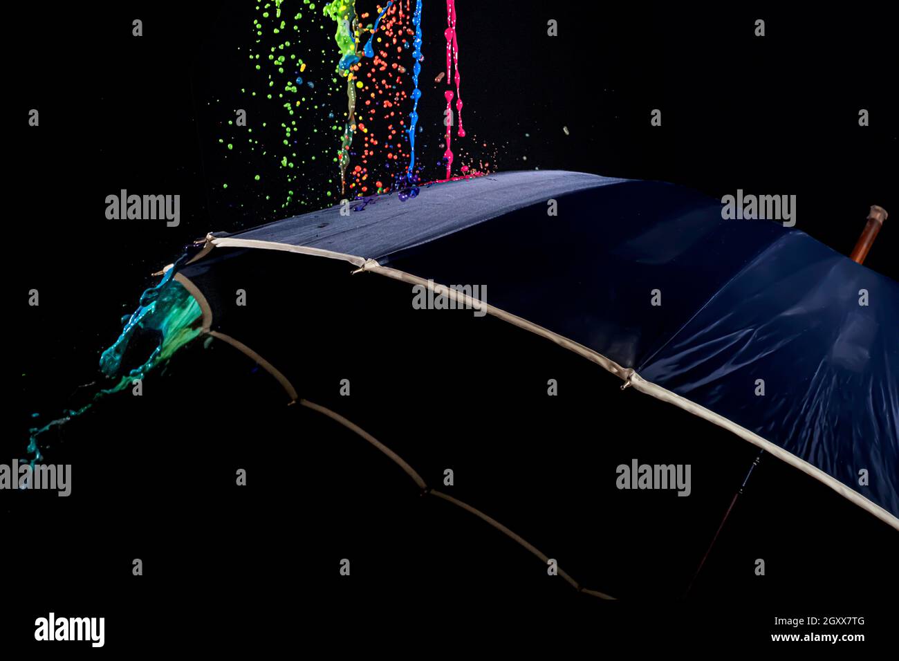 Liquido multicolore che cade su un ombrello Foto Stock