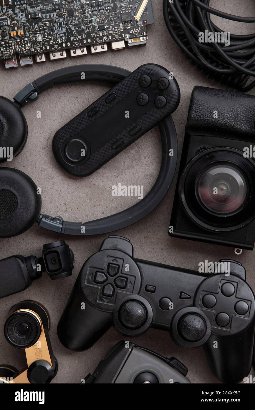 Stesa piatta e overhead di dispositivi e gadget in tecnologia nera su sfondo grigio Foto Stock