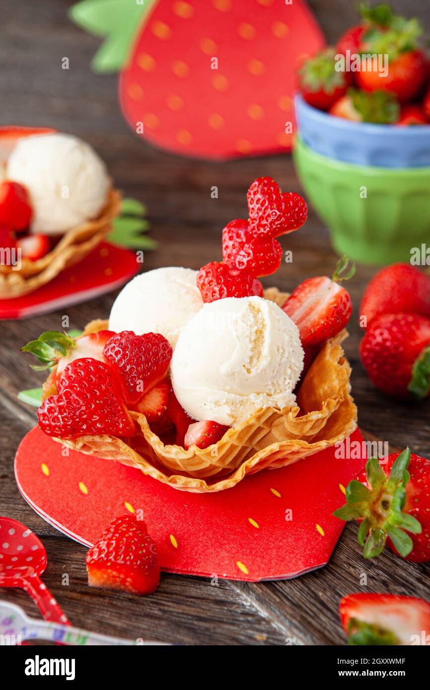 Gelato alla vaniglia con fragole fresche in tazze di waffle Foto Stock