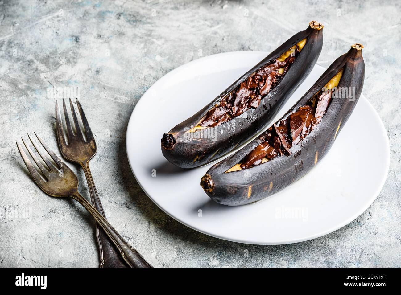 Banane grigliate con cioccolato fondente e succo di agrumi Foto Stock