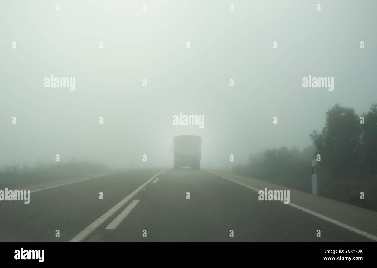 Guida dietro un carrello sotto nebbia fitta. Visibilità molto scarsa Foto Stock