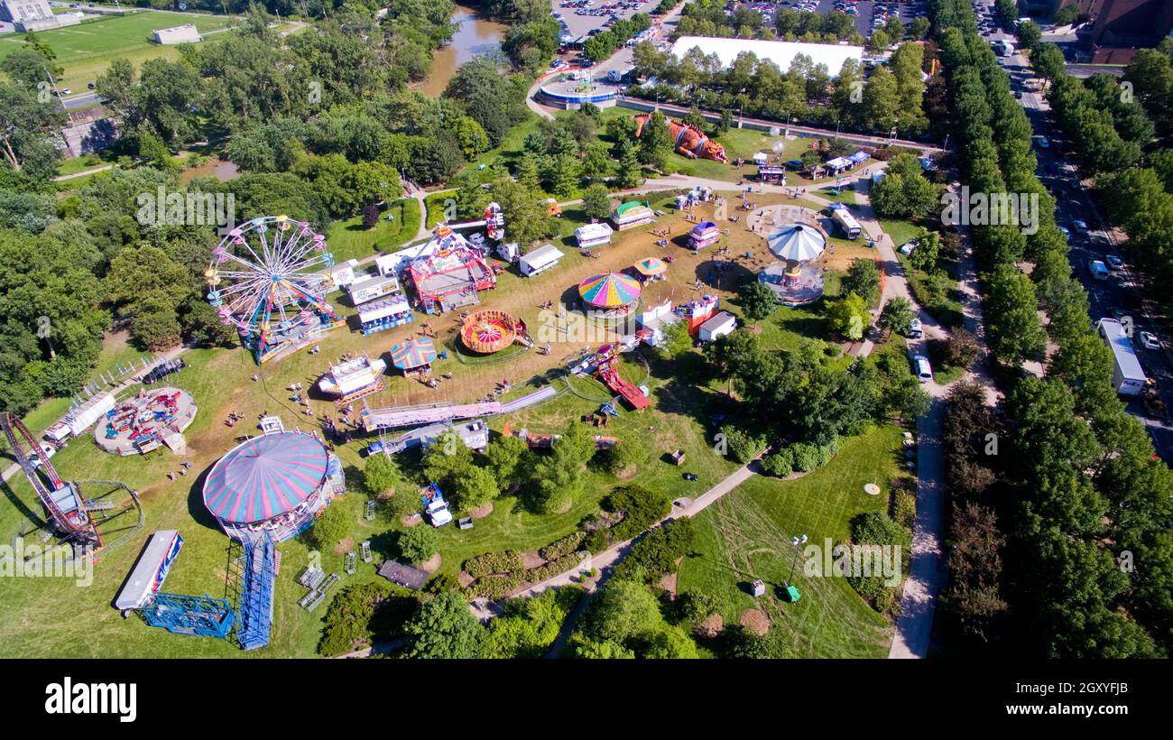 Una piccola festa o fiera circondata da alberi accade in una piccola città Foto Stock