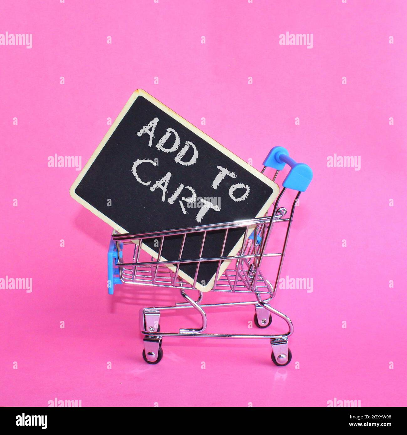 Carrello con testo DA AGGIUNGERE AL CARRELLO su sfondo rosa. Foto Stock