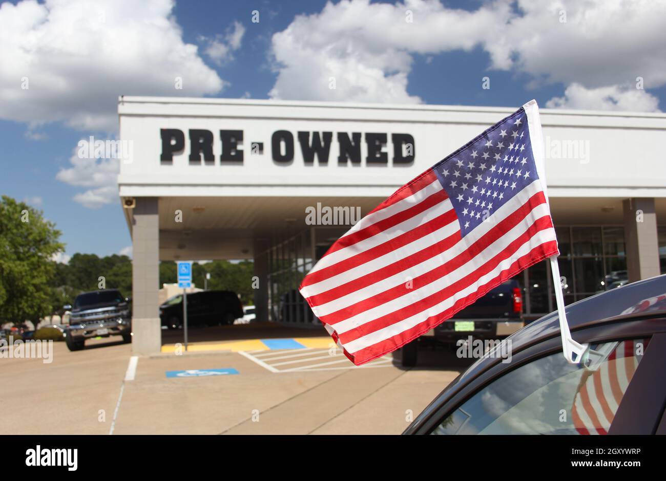 Concessionario di automobili usato con bandiera americana Foto Stock