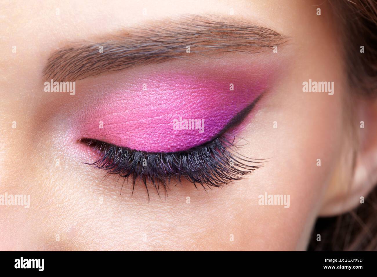 Macro shot closeup dell'occhio femminile chiuso. Donna con naturale sera Vogue viso bellezza trucco. Ragazza con pelle perfetta e occhi rosa ombre. Foto Stock
