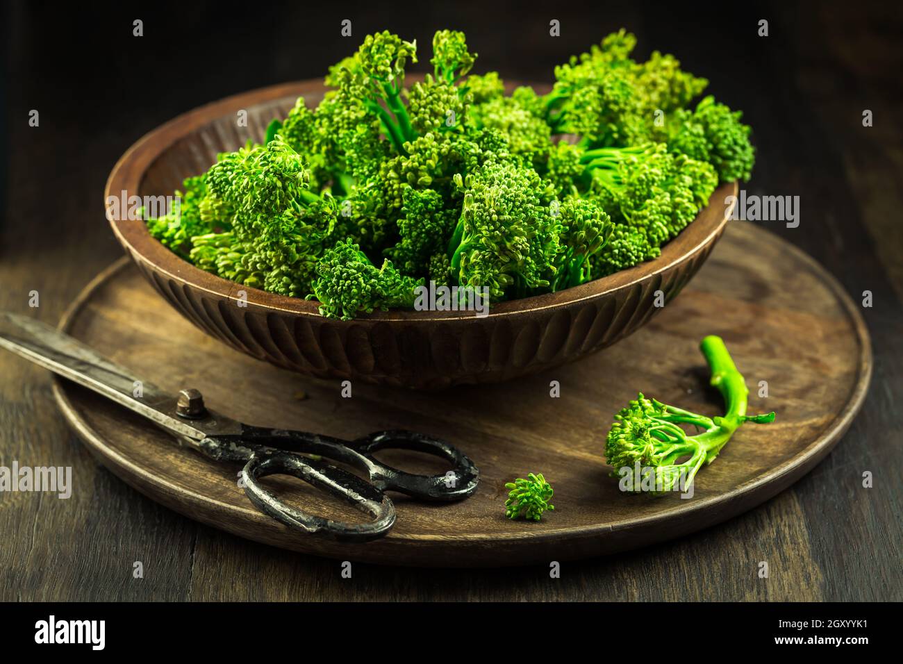 Broccolini organici (bimi) in ciotola su fondo ligneo Foto Stock