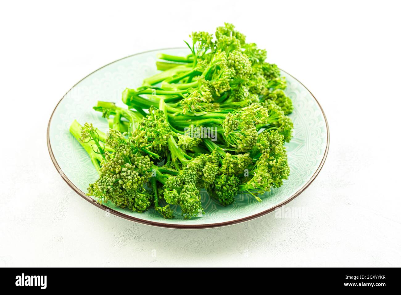 Broccolini organici (bimi) in ciotola su fondo bianco Foto Stock