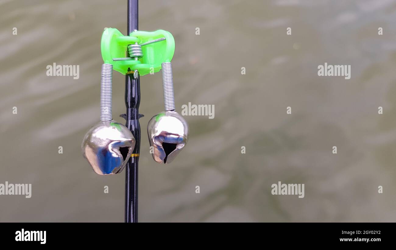 Campane di pesca d'argento sono indossate su una canna da pesca durante la pesca. Segnale di chiamata morso, sulla punta dell'asta. Un allarme morso ti avviserà di un morso. Pesca Foto Stock