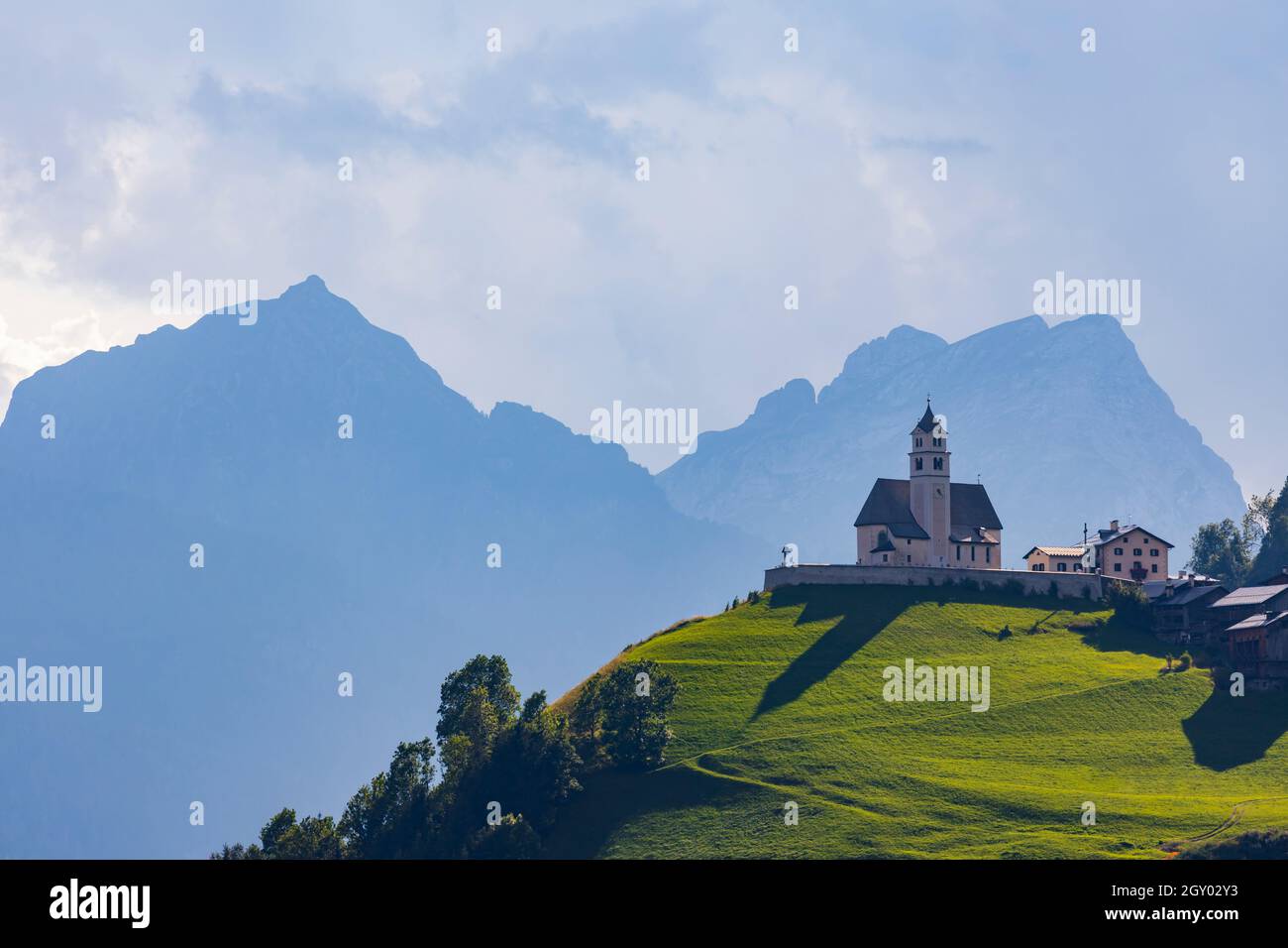 Paesaggio montano con villaggi di Colle Santa Lucia con chiesa in Dolomiti, Alto Adige, Italia Foto Stock