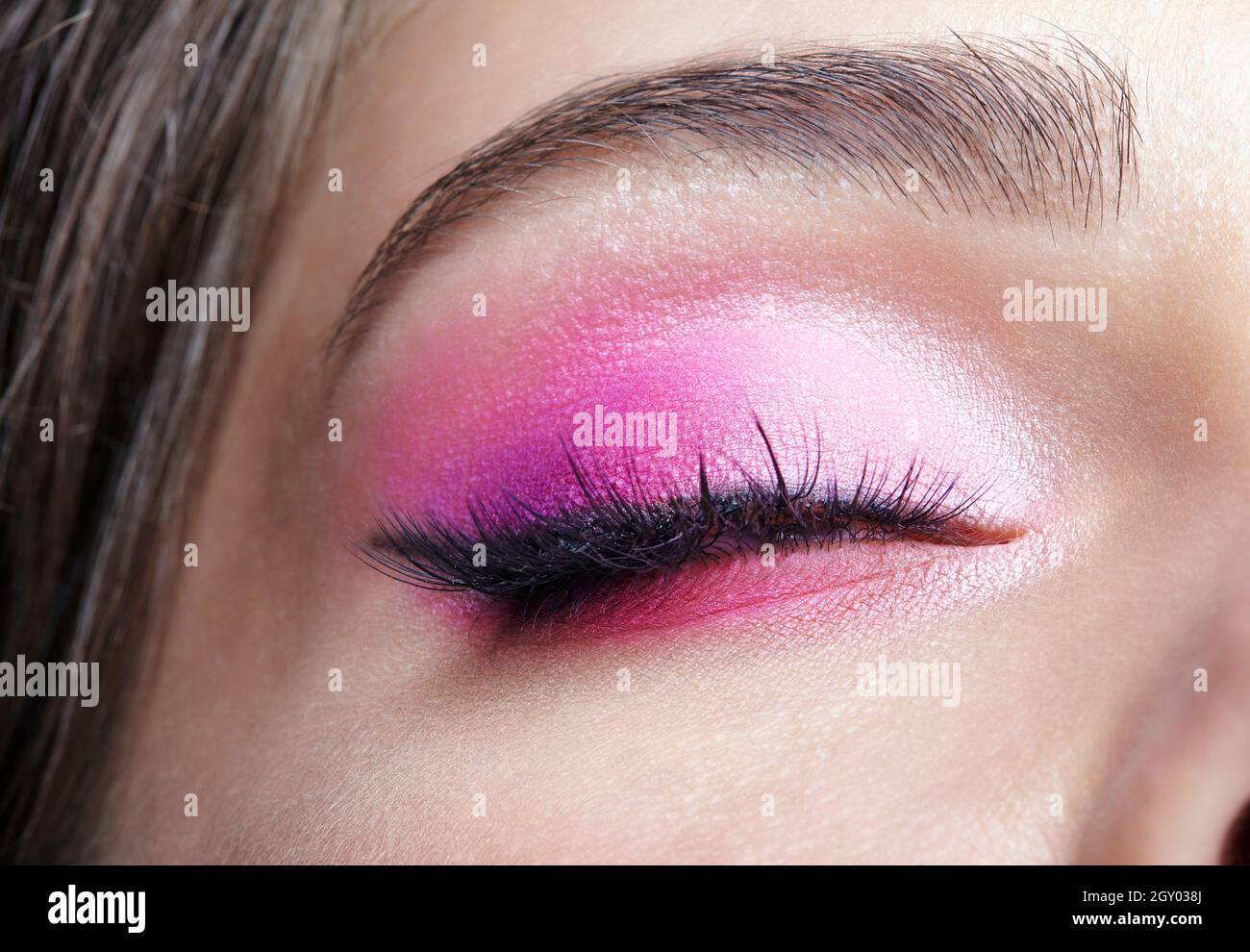 Macro shot closeup dell'occhio femminile chiuso. Donna con naturale sera Vogue viso bellezza trucco. Ragazza con pelle perfetta e occhi rosa ombre. Foto Stock