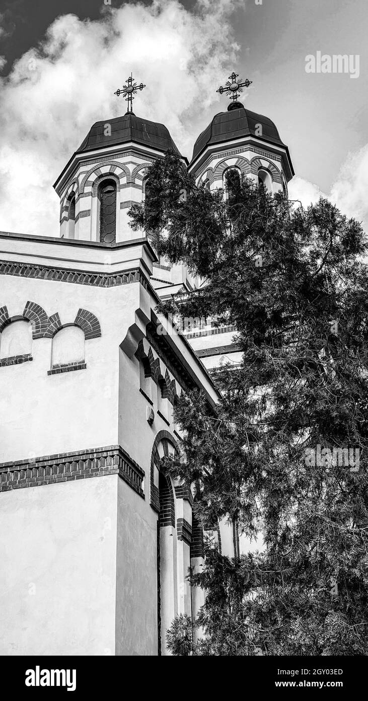 Bianco e nero classica vecchia chiesa ortodossa cristiana rumena con cielo e nuvole Foto Stock