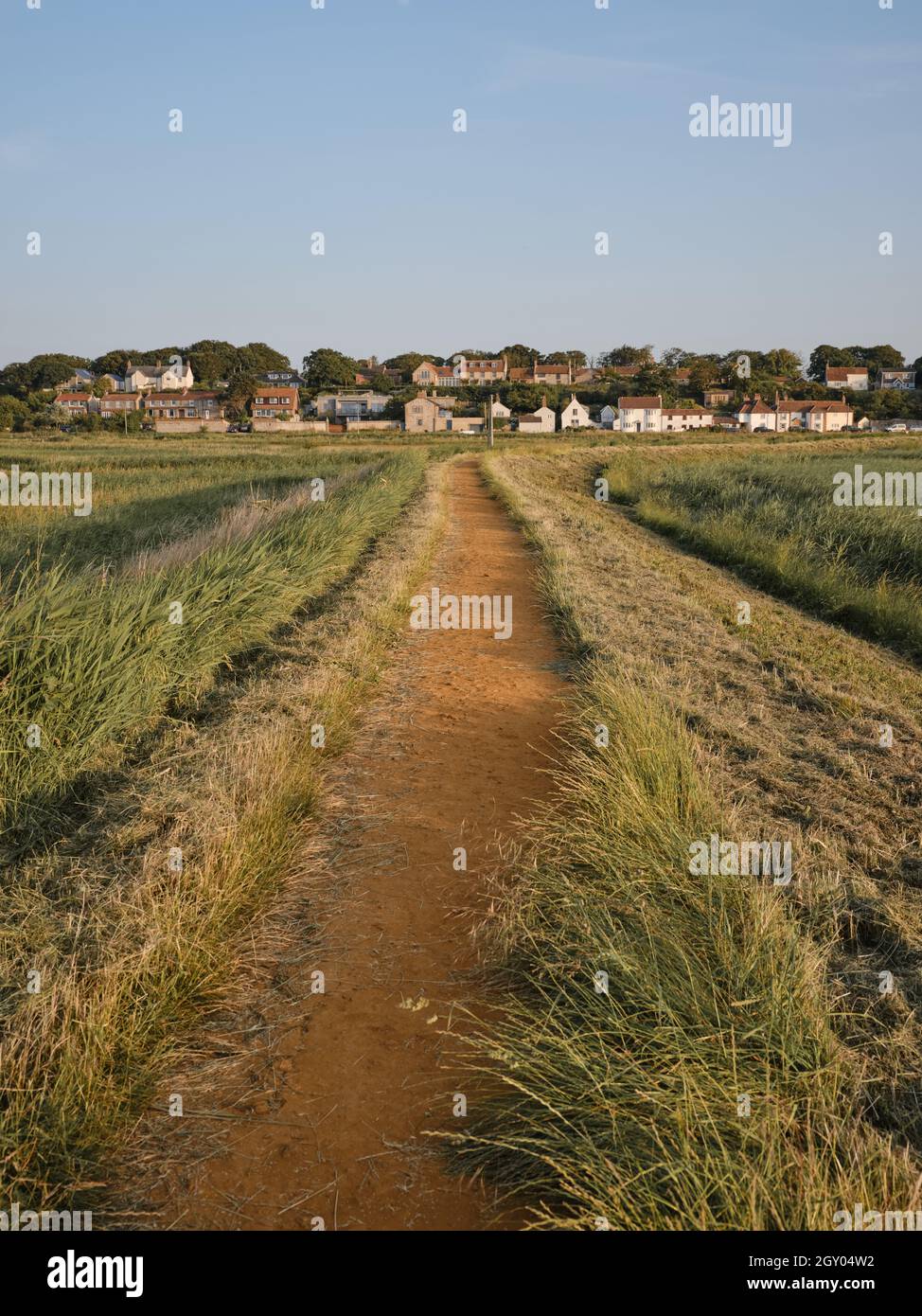 Tornando a piedi dalla spiaggia a Cley accanto al villaggio di mare lungo il sentiero rialzato attraverso la riserva naturale di Cley Marshes Norfolk Inghilterra UK Foto Stock