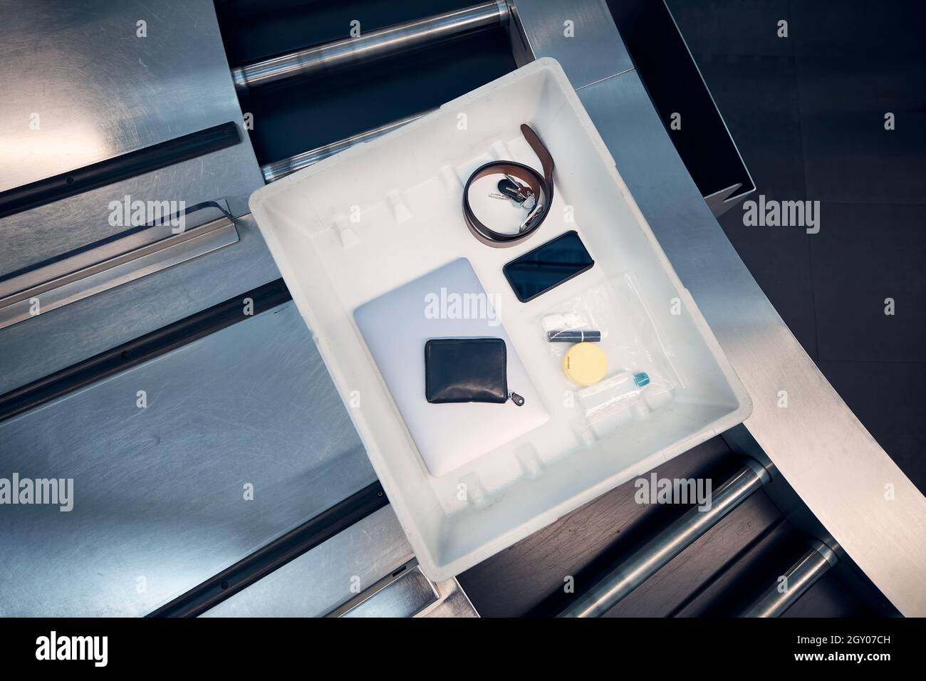 Oggetti personali, liquidi e computer portatile in container al controllo di sicurezza dell'aeroporto prima del volo. Foto Stock