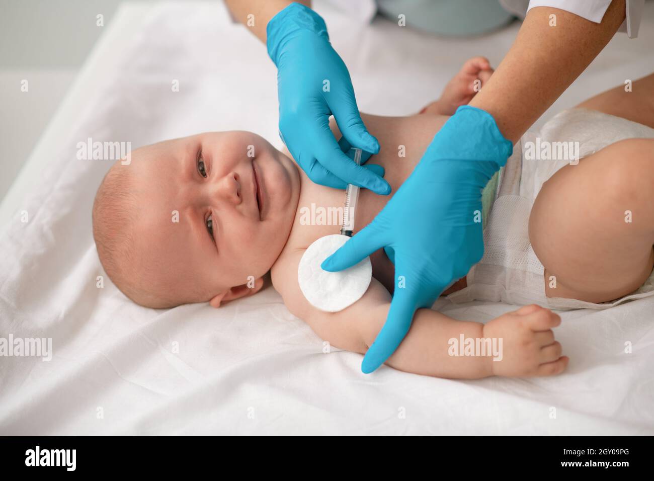 Bambino tranquillo e carino vaccinato da un operatore sanitario Foto Stock