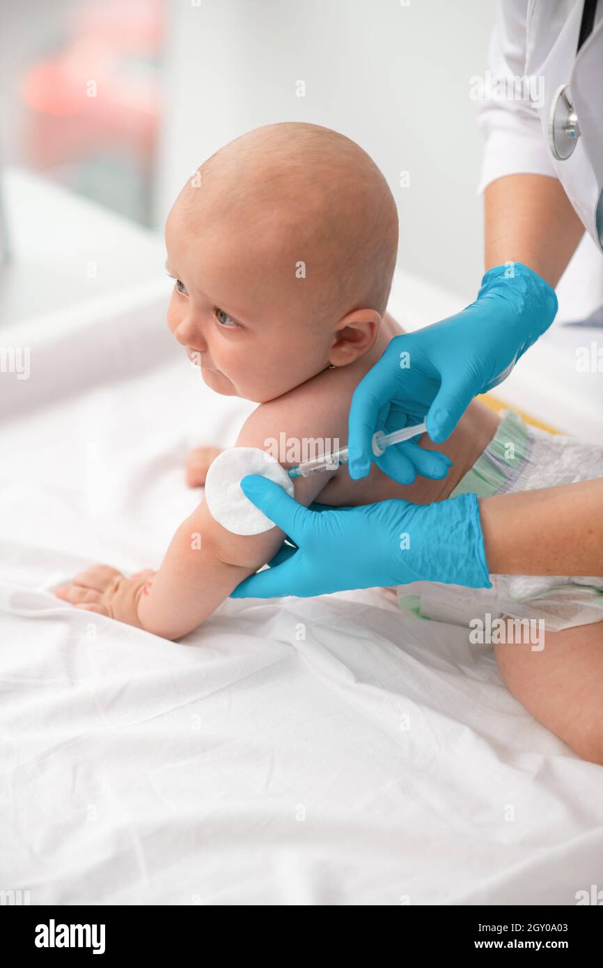 Bambino che riceve un'iniezione nella parte superiore del braccio Foto Stock