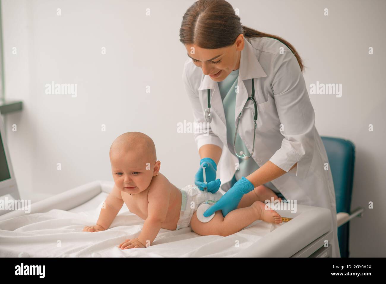 Sorridente medico che inietta un neonato Foto Stock