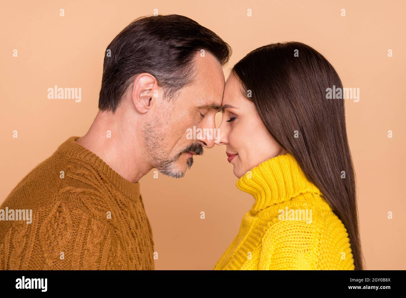 Foto del profilo di coppia brunette amore vestire cadere caldo maglioni  isolato su sfondo di colore beige Foto stock - Alamy
