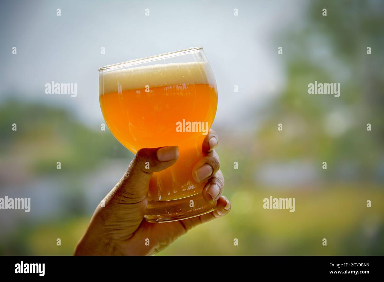 Birra d'oro in un bicchiere di birra per l'Oktoberfest in mano. Pinta di birre alla spina di grano alla Feste di Bachelorette dell'amicizia al Bar. Giovani vita notturna con Foto Stock
