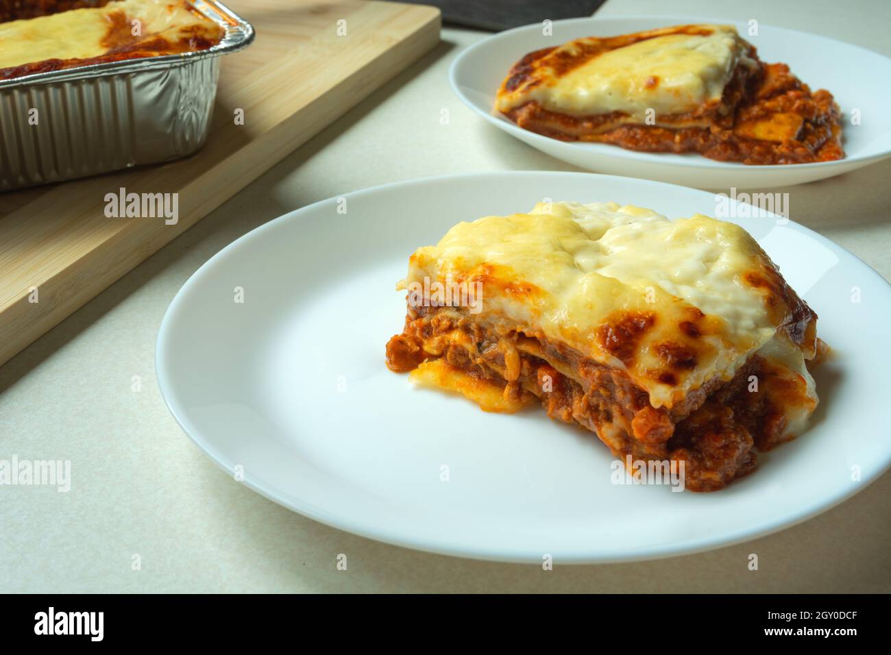 Pezzi di lasagna cotti su un piatto bianco Foto Stock