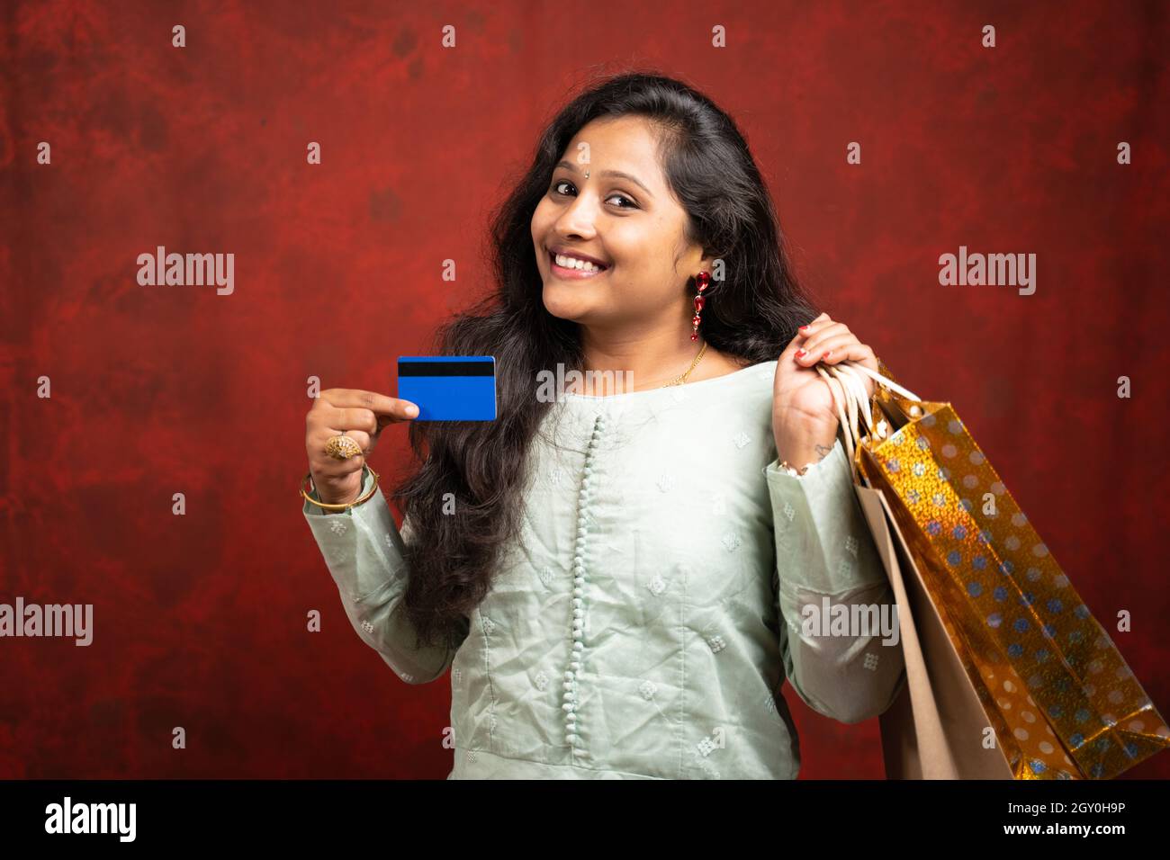 Ragazza indiana sorridente felice con la borsa di shopping e la carta di credito - concetto di vendite di shopping festa Foto Stock