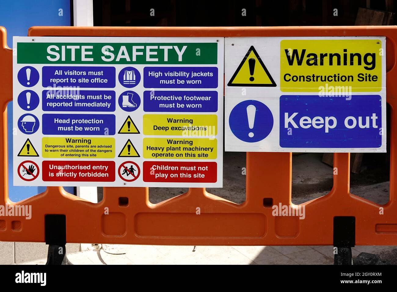 Gli interni dell'edificio sono lavorati da costruttori con grandi strutture di sicurezza del sito tenere fuori il cartello di avviso sulla barriera di plastica mobile attraverso l'ingresso nel Regno Unito Foto Stock