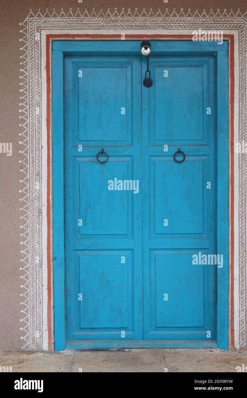 Vecchia porta di legno con una cornice bianca a motivi geometrici Foto Stock