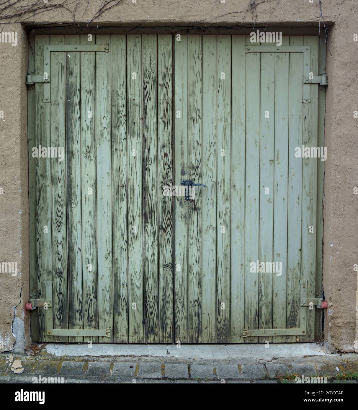 Vecchia porta verde in legno con serratura e maniglia arrugginita Foto Stock