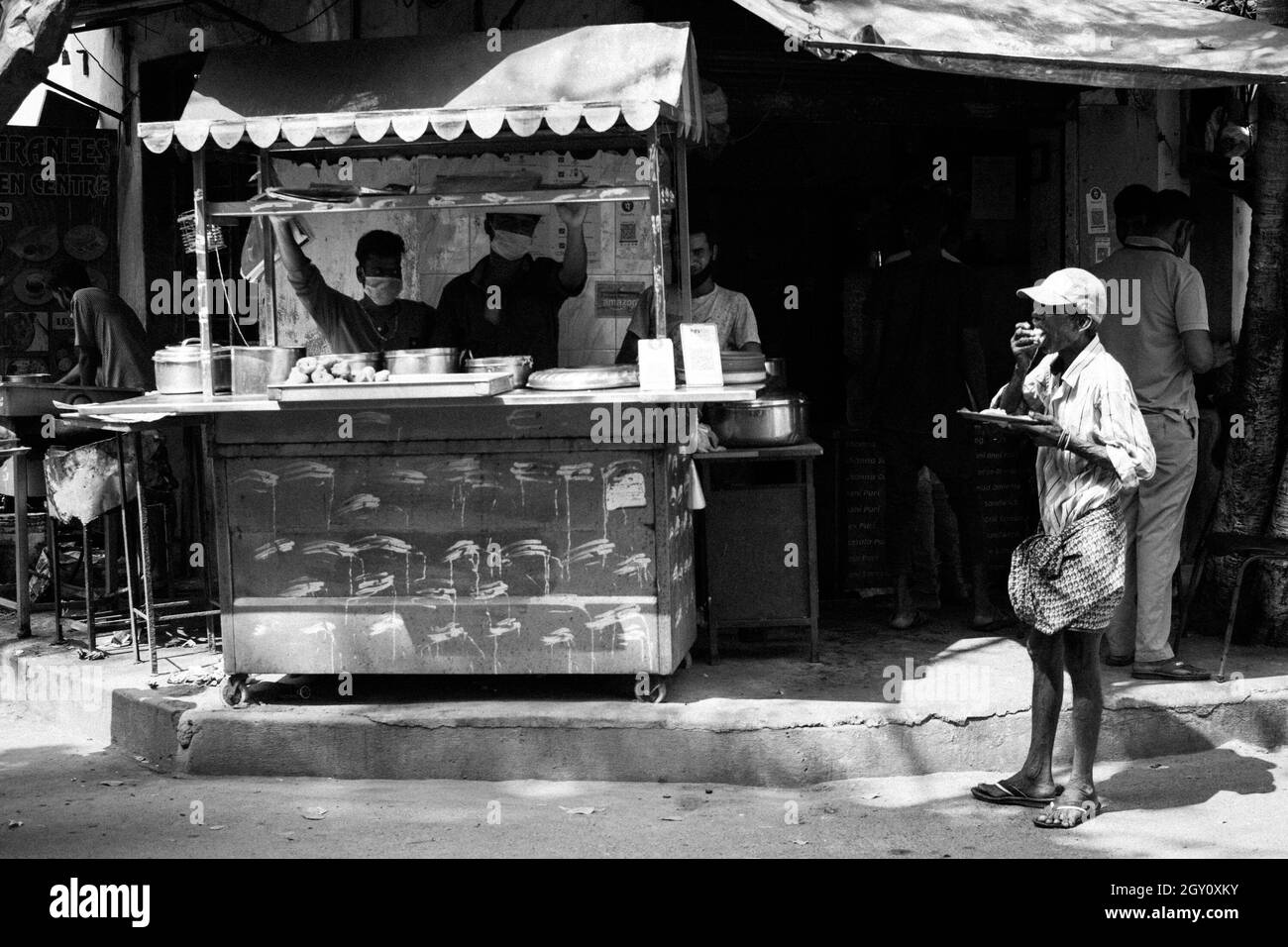 Un lavoratore informale che ha un pasto in un ristorante stradale, Chennai, 2020. Foto Stock