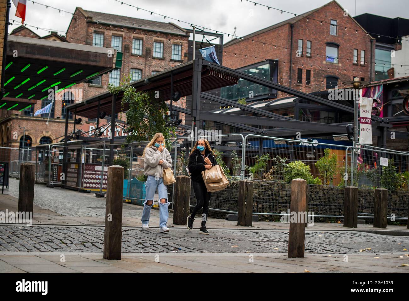 Due donne camminano attraverso Concert Square nel centro della città di Liverpool, che ora è soggetto alle restrizioni di livello 3, Merseyside, Regno Unito Foto Stock