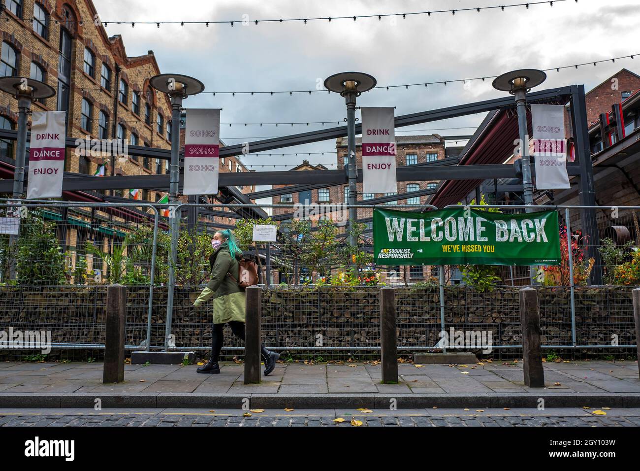 Una donna cammina accanto ai bar chiusi in Concert Square nel centro di Liverpool, che è ora sotto le restrizioni Tier 3, Merseyside, Regno Unito Foto Stock