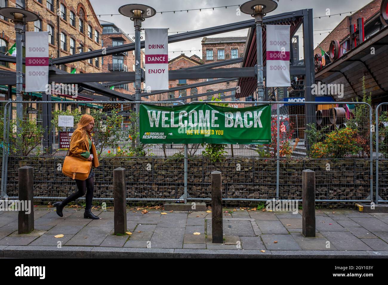 Una donna cammina accanto ai bar chiusi in Concert Square nel centro di Liverpool, che è ora sotto le restrizioni Tier 3, Merseyside, Regno Unito Foto Stock